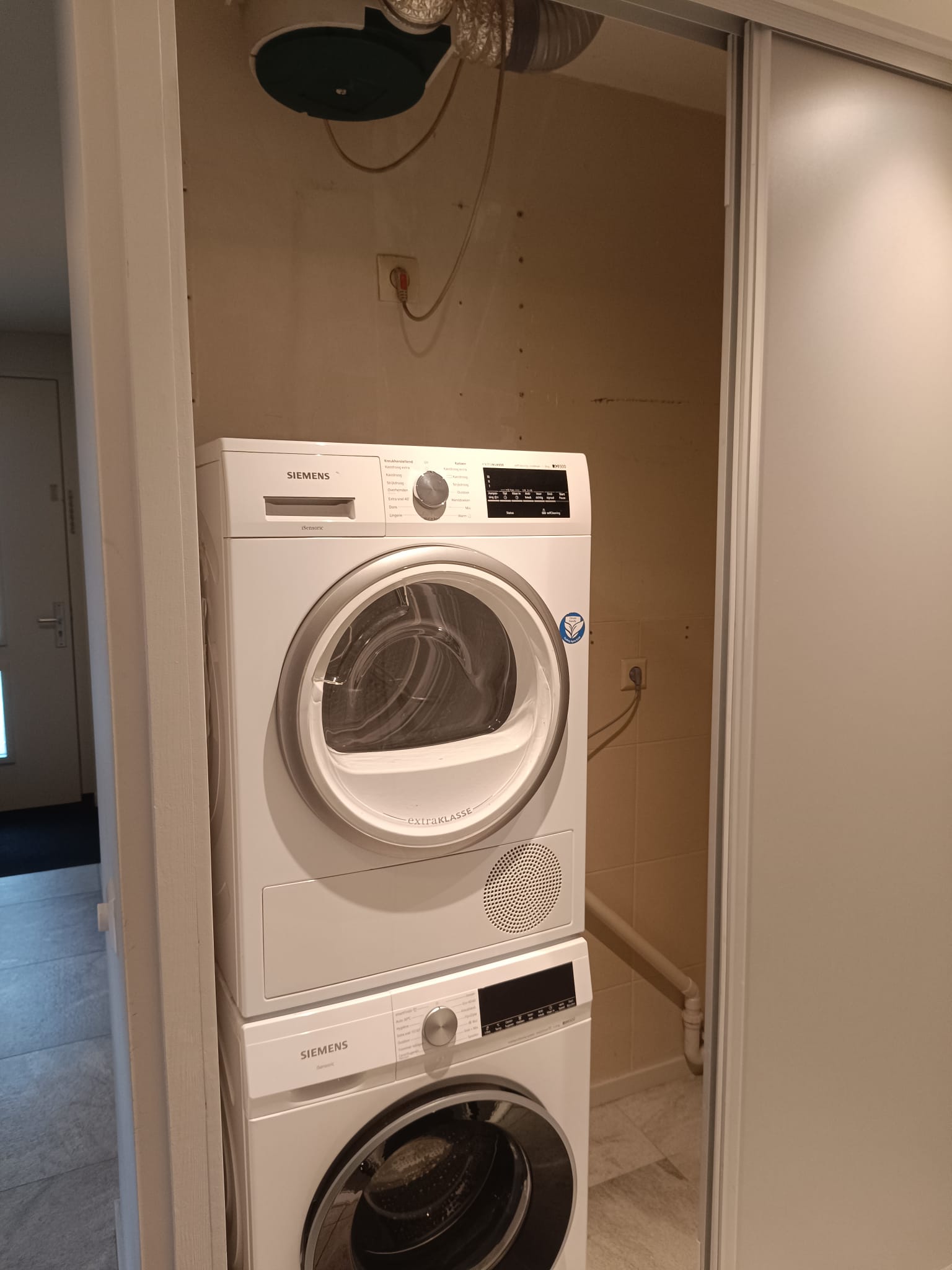 Bestaande wasruimte voor maatkast renovatie met wasmachine en droger