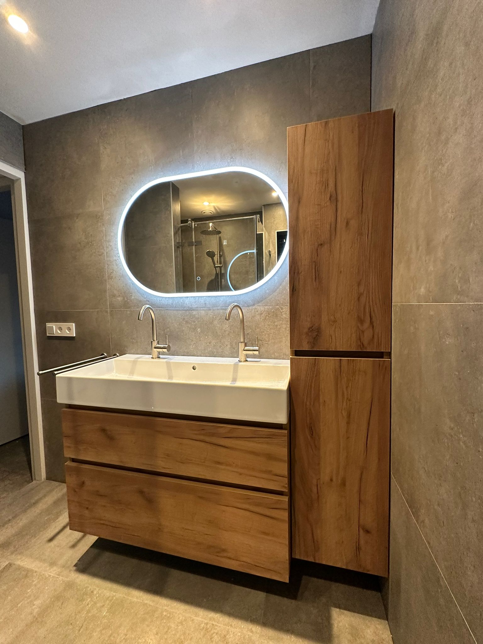 Moderne wastafel met houtlook meubel in badkamer IJsselstein