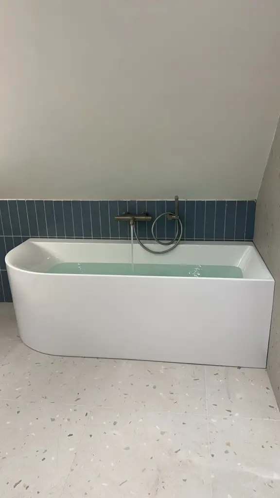 Vrijstaand bad met blauwe tegelwand 